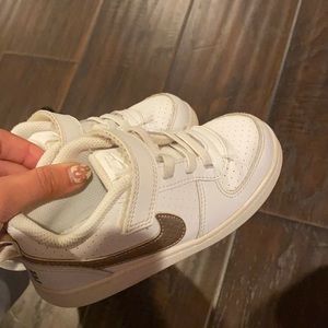 White kids Nikes with gold check